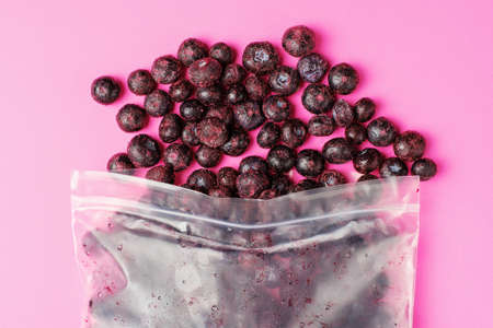 Packages with frozen blueberry on pink background, top view.の写真素材