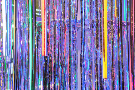 Vertical stripes multicolored tinsel brightly sparkles, abstract background close up.