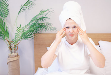 Portrait of young woman who is put on face of sheet moisturizing mask.