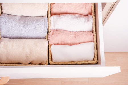 Folded towels in closet close-up, space organization concept.の写真素材