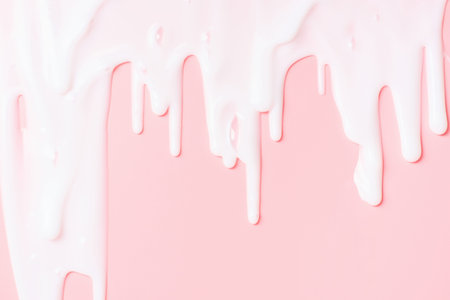 liquid moisturizing shampoo dripping down on pink background close-up.