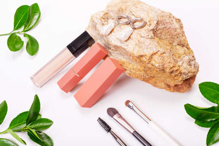 Decorative cosmetics and green plants on white background.の写真素材