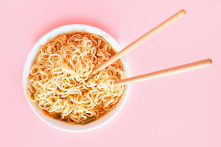 A plate with ready ramen and wooden sticks on pink background, view from aboveの写真素材