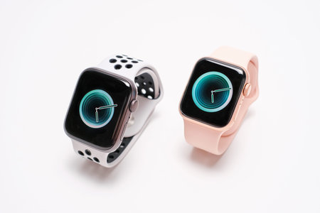 Seoul - 27.07.2022: Two Apple Watches with pink and gray strap on white background close-up.