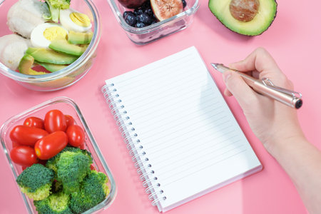 Blank notepad, female hand and food box, meal plan concept.の写真素材