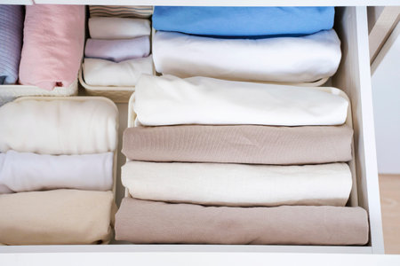Clothes folded in a box in a dresser close-up, space organization concept.