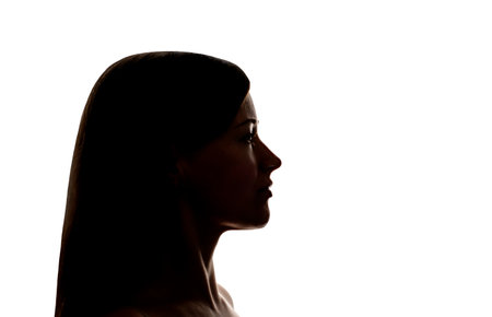 Dark silhouette of a young woman on white background side view, the concept of anonymity.の写真素材