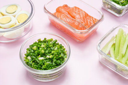 Healthy food in glass lunch boxes on pink background close up.の写真素材
