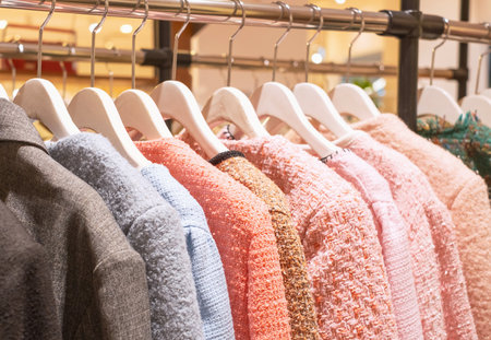 Tweed jackets hanging on hangers in a female clothing store close-up, side view.の写真素材