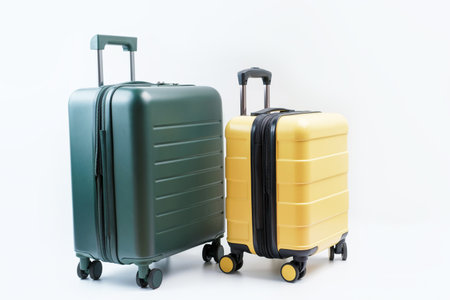 Yellow and green suitcase on white background close-up, travel concept.の写真素材