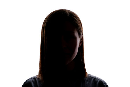 Dark silhouette of a young woman on white background front view.の写真素材