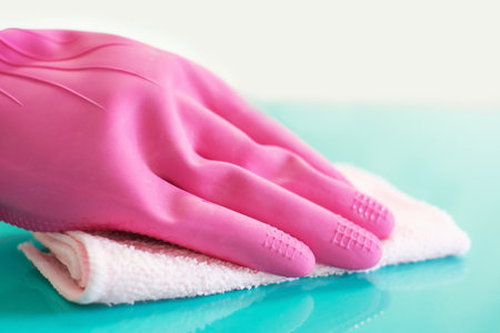 Female hand in pink glove wipes surface with rag.の写真素材