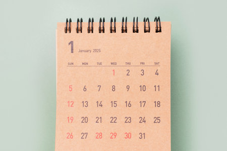 Brown calendar for January 2025 on green background close-up, planning concept.の写真素材