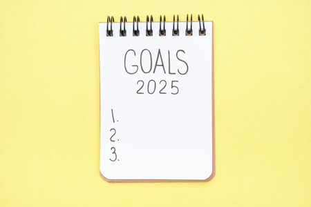 The inscription goals 2025 on notepad on yellow background, top view.の写真素材