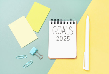 The inscription goals 2025 on notepad on a yellow and green background, top view.の写真素材
