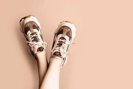 Female legs in sneakers upside down close-up in a trendy color.の写真素材