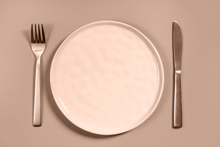Empty plate, fork and knife in trending color of year 2025.の写真素材