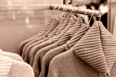 Trendy Mocha Mousse color woolen knitted sweaters hanging on hangers in the store.
