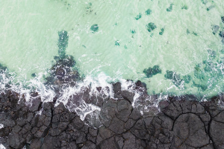Ocean and volcanic rocks close-up aerial view, natural background.の写真素材