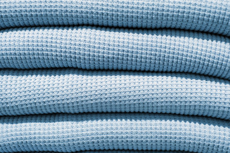 Folded stack of blue knitted sweaters close-up, texture and background.の写真素材