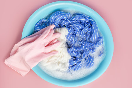 Clothes washed with basin close-up on a pink background, top view.の写真素材
