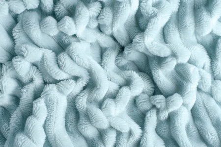 Texture of soft folded blanket mint color, top view.