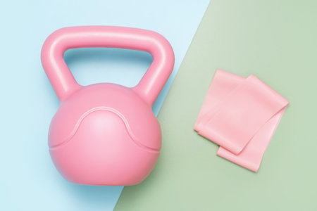 Kettlebell and elastic band on a blue and green background top view close-up.の写真素材