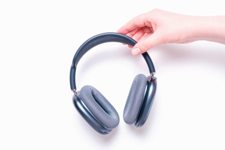 Seoul - 19.12.2024: Female hands holding headphones AirPods Max on white background close-up, top view.の写真素材