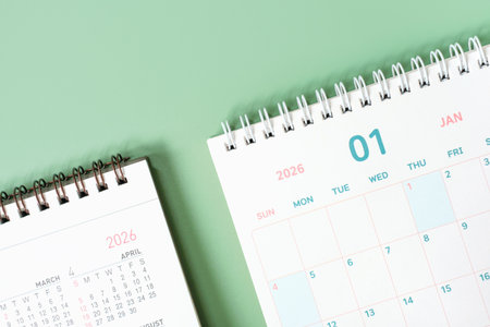 Paper calendars for 2026 on green background close-up.の写真素材