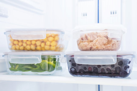 Vegetables and chickpeas in glass containers in the refrigerator, food storage concept.