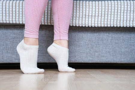 Legs doing exercises lifting on toes close-up, home workout concept.の写真素材