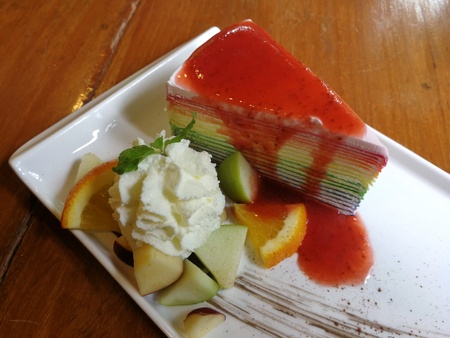 Rainbow crepe cake with a cup of strawberry juice serving with whipped cream : Angle Viewの写真素材