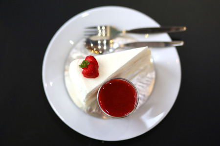 Crepe cake with strawberry sauce on black tableの写真素材