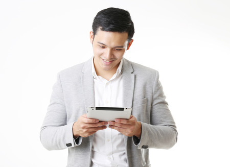 Portrait of Asian Man with a tablet in Isolated Backgroundの写真素材