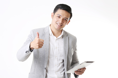 Portrait of Asian Man with a tablet in Isolated Backgroundの写真素材