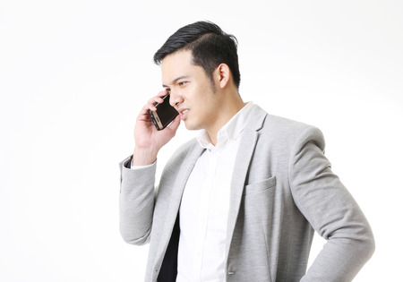 Portrait of Asian Man with mobile phone in Isolated Backgroundの写真素材