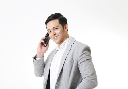 Portrait of Asian Man with mobile phone in Isolated Backgroundの写真素材