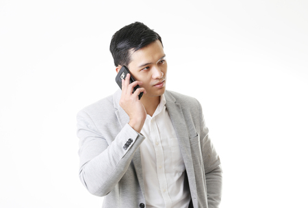 Portrait of Asian Man with mobile phone in Isolated Backgroundの写真素材