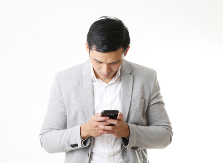Portrait of Asian Man with mobile phone in Isolated Backgroundの写真素材