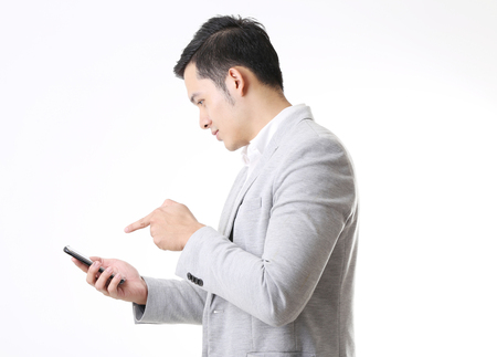 Portrait of Asian Man with mobile phone in Isolated Backgroundの写真素材