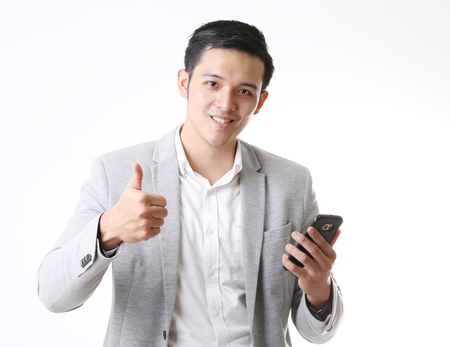 Portrait of Asian Man with mobile phone in Isolated Backgroundの写真素材