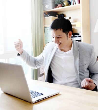 Young asian businessman working with laptop in home officeの写真素材