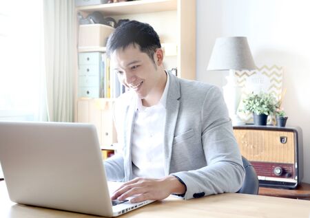 Young asian businessman working with laptop in home officeの写真素材