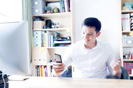 A Portrait of young asian man working with laptop  and showing gesture signの写真素材