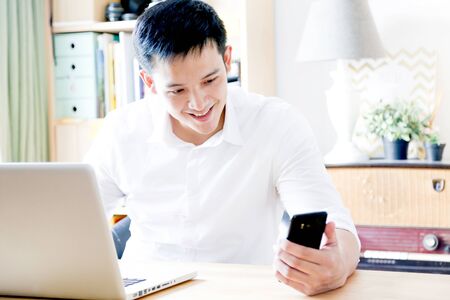 A Portrait of young asian man working with laptop  and showing gesture signの写真素材
