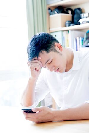 A Portrait of young asian man working with laptop  and showing gesture signの写真素材