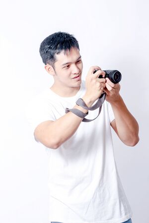 A Portrait of young asian man in white shirt and blue jeans  showing gesture sign or devicesの写真素材