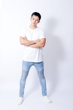 A Portrait of young asian man in white shirt and blue jeans  showing gesture sign or devicesの写真素材