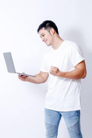 A Portrait of young asian man in white shirt and blue jeans  showing gesture sign or devicesの写真素材