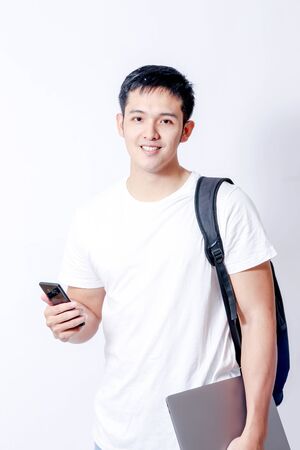 A Portrait of young asian man in white shirt and blue jeans  showing gesture sign or devicesの写真素材